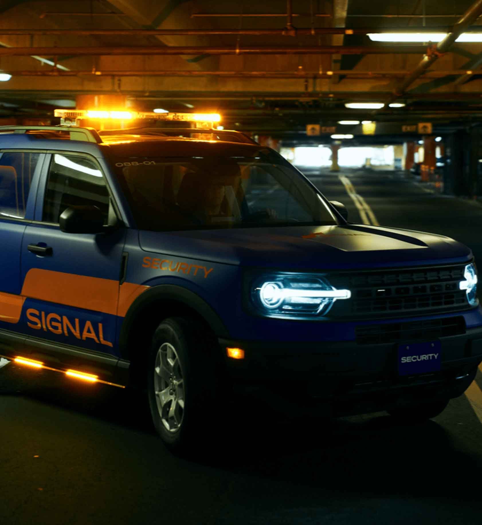 Signal company vehicle with its lights on in a dark parking garage