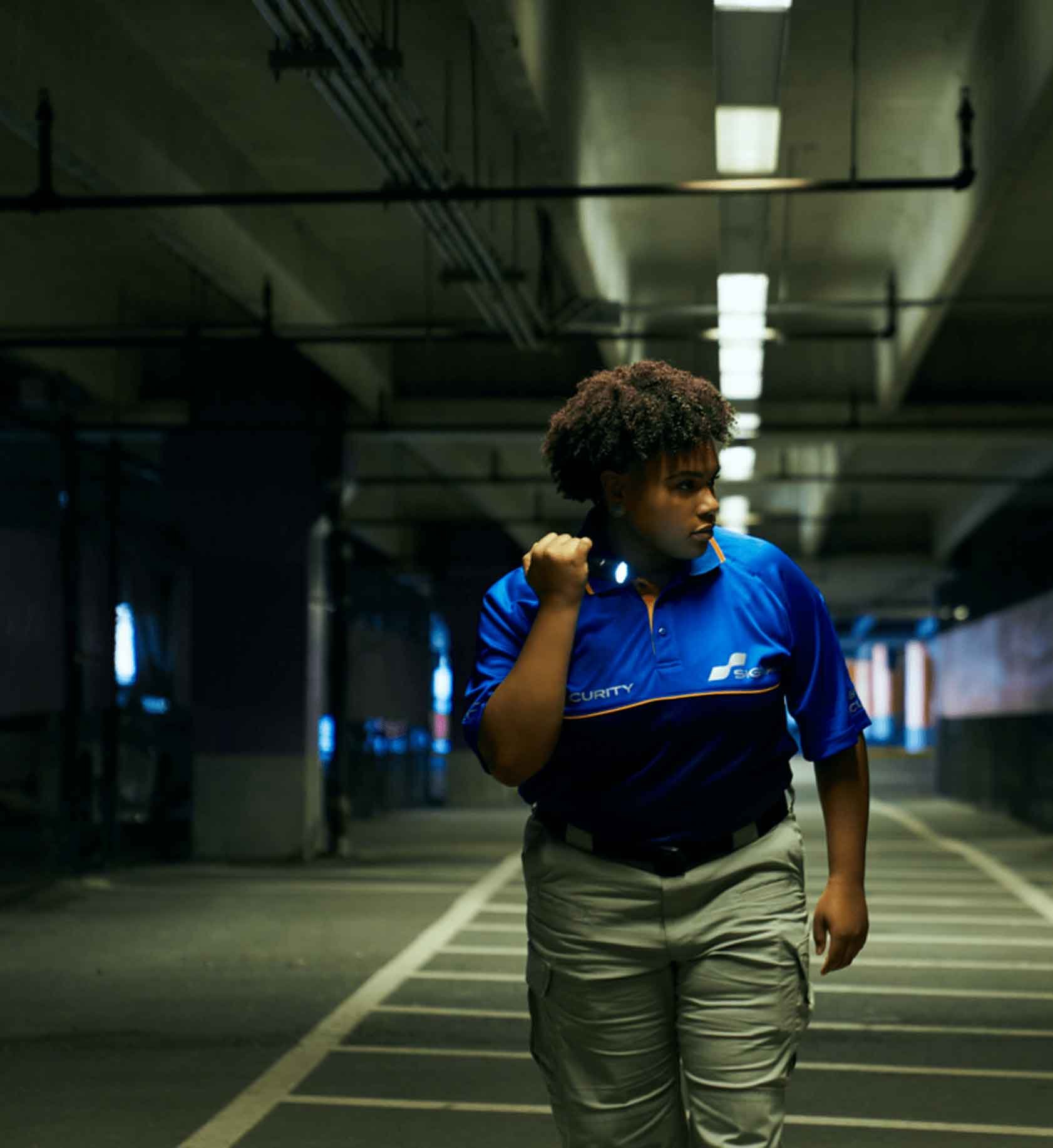 Signal employee shining a flashlight in a parking garage