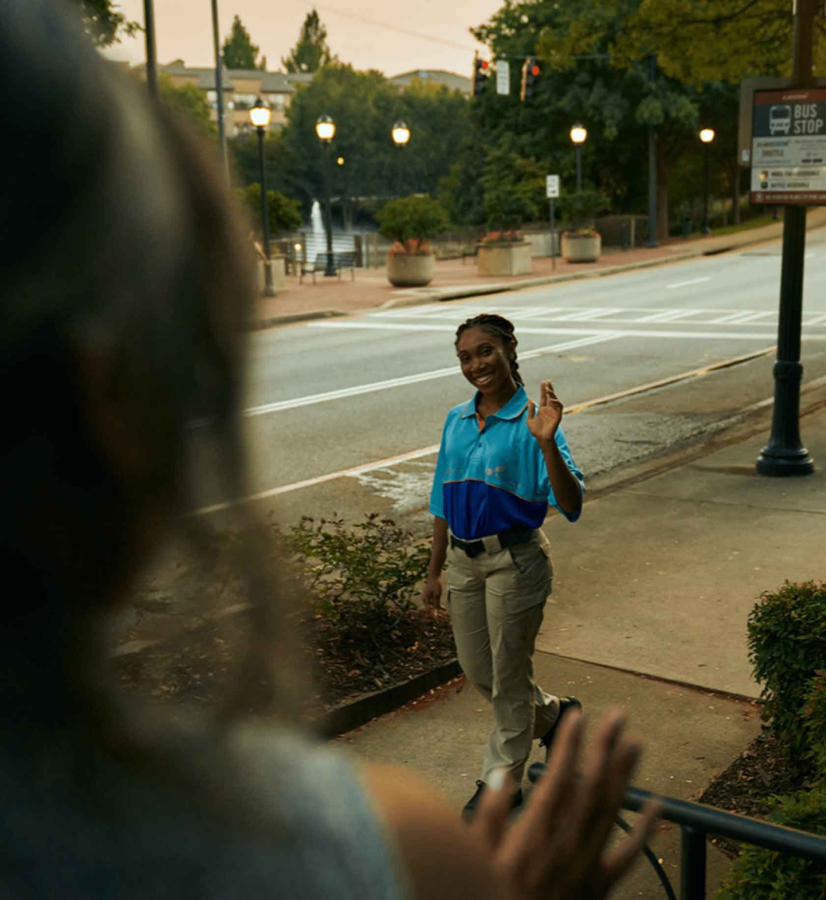 Signal employee waving ta someone from the sidewalk