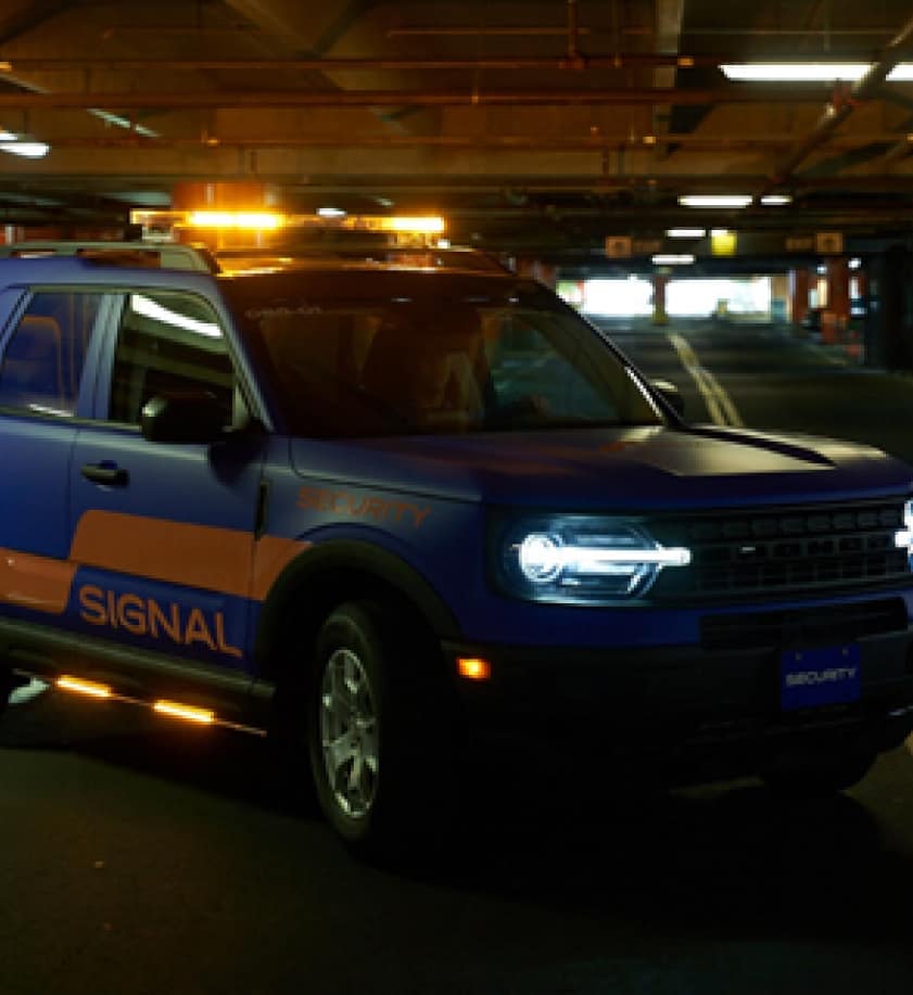 Signal company vehicle inside of a dark parking garage